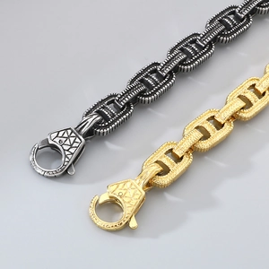 Dettaglio di catene punk vintage in oro e argento con texture geometrica in rilievo