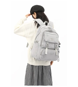 Rear view of a grey nylon backpack with cute bear prints and multi-pocket design on model