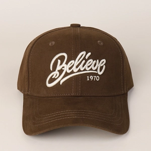 Close-up of 3D embroidered white lettering on a dark brown cotton twill baseball cap