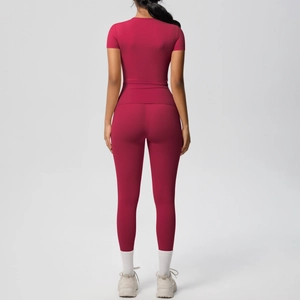 Detail of dark magenta yoga set featuring high-waisted leggings and short sleeve crop top