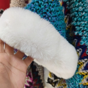 Detail of white faux rabbit fur trim on a Bohemian style poncho with ethnic textures
