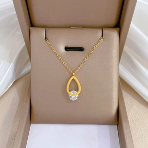 Dettaglio del ciondolo in zircone a goccia su catena d'oro in una scatola per gioielli