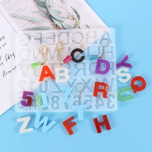 Silicone alphabet and number mold with colorful resin keychain samples on blue background