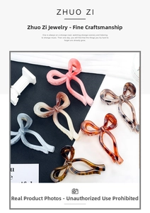 Detail of six acetate bow hair claws in gradient pink, amber, and marble textures