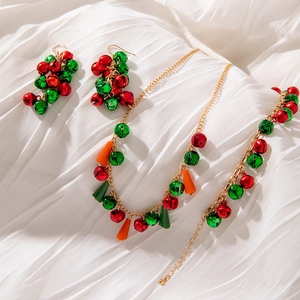 Close-up of Christmas jewelry set with red and green bells and gold beaded necklace