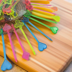 Detail of colorful poker card pattern plastic fruit picks on a wooden board
