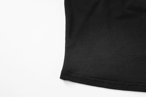 Vue détaillée de la texture du tissu en coton noir et des coutures sur l'ourlet de la robe