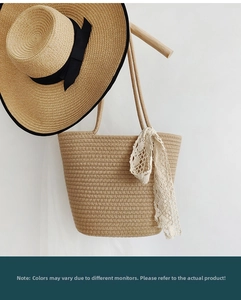 Detail of woven straw tote bag with rope straps and matching wide-brim summer hat