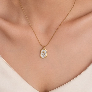 Detail of vintage gold tulip pendant with white oil drip on a sleek snake chain