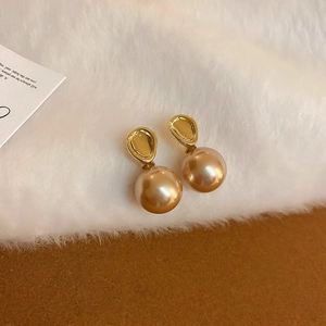 Détails de boucles d'oreilles perles champagne et accents métalliques dorés irréguliers