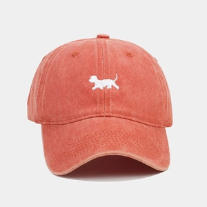 Dettaglio del tessuto in cotone lavato e del ricamo a forma di cucciolo bianco sul cappello