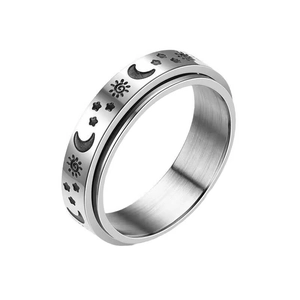 Detail view of silver spinner ring with engraved sun, moon and star patterns on steel