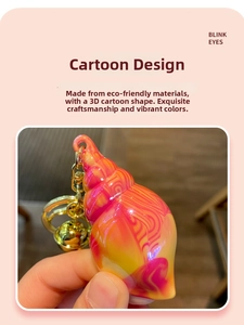 Detailed macro view of colorful acrylic conch shell keychain with golden bell and metal ring