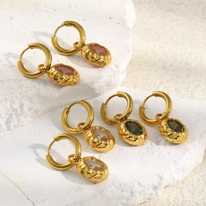 Detail of 18K gold-plated oval zircon earrings with hammered texture on stone base