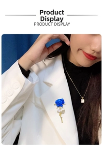 Blue enamel rose brooch with rhinestones and pearl on a white blazer lapel