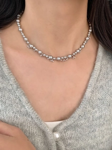 Close-up of pearl necklace with small zircon pendants worn on a woman's neck