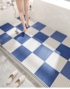Close-up of blue and white TPE bathroom floor tiles with drainage holes for anti-slip safety