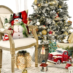 Christmas pillow covers with snowman and red truck prints on a wooden chair
