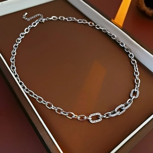 Detail of silver chain necklace with zircon rectangles and polished oval links