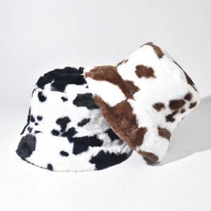 Detail showing plush cow print bucket hats in black and brown faux fur textures