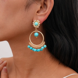 Bohemian gold hoop earrings with turquoise stones and rhinestone accents on model