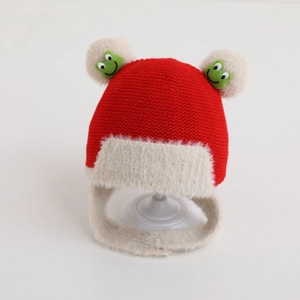 Close-up of baby winter knit hat with white faux fur lining and green frog embroidery