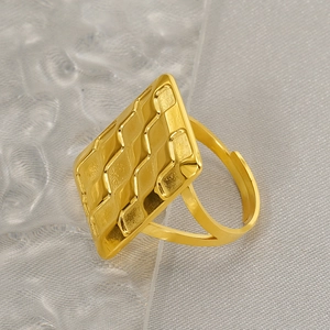 Close-up of golden geometric ring with quilted wave texture and adjustable open band