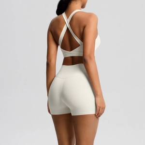 Detail von Cross-Back Yoga-Bra und High-Waist-Shorts in cremeweißem Stretchgewebe