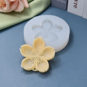 Cherry blossom silicone mold with a finished 5-petal flower craft on a blue desk
