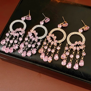 Detail of pink pear-shaped gemstone earrings with tassels in gold and silver finishes