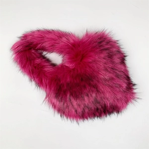 Detail of heart-shaped faux fur crossbody bag in vibrant rose pink and black colors