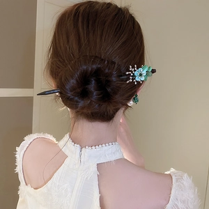 Detailed view of an antique pearl flower hair pin featuring green leaves and blue petals