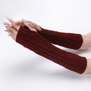 Close-up of deep red cable-knit fingerless gloves showing arm-warming texture and fit