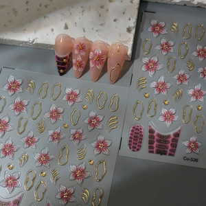 Detail view of pink floral nail stickers with gold outlines and 3D textured cherry blossoms