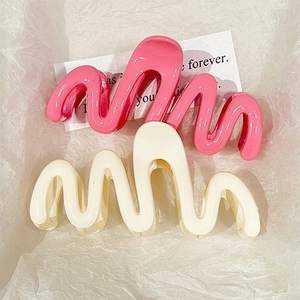 Jelly colored wavy shark hair clips in glossy pink and cream white on white background