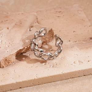 Detailed close-up of a silver-tone chain-link open ring on a textured stone surface