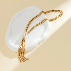 Detail der goldenen Schlangenkette mit Perlen-Schiebeschnalle und eleganten Quasten