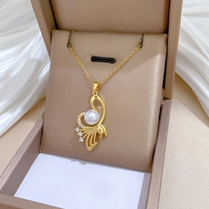 Macro detail of gold-plated eagle wing pendant with pearl and crystal in jewelry box