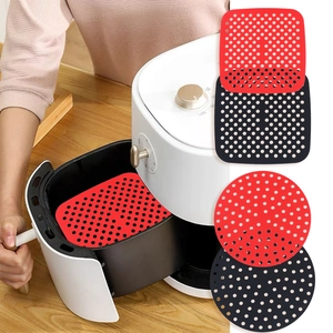 Dettaglio dei tappetini in silicone rosso e nero per friggitrice ad aria, forme quadrate e tonde