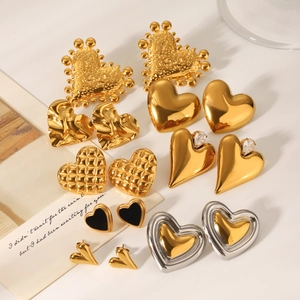 Flat lay of heart stud earrings in gold and silver with zircon and matte finishes