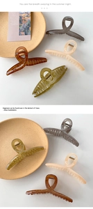 Detail shot of large crisscross hair claw clips in four vintage colors with glossy finish