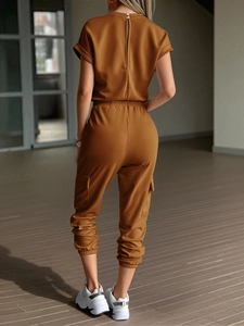 Rear view of brown short sleeve jumpsuit featuring cargo pants with large side pockets