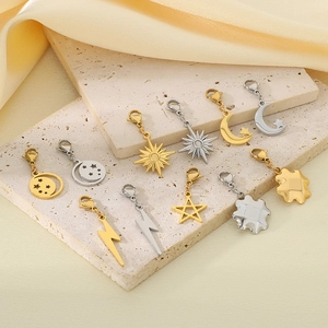 Minimalist gold and silver star moon lightning pendants with lobster clasps on travertine