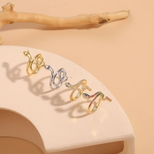Detail view of gold and silver snake rings with colorful zircon inlay on display stand