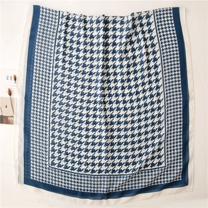 Detail of blue and white houndstooth scarf showing fine cotton texture and neat hemmed edges