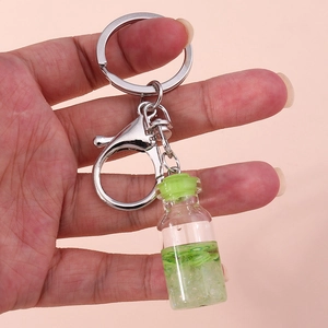 Close-up of a fruit wishing bottle keychain with green liquid and kiwi slices