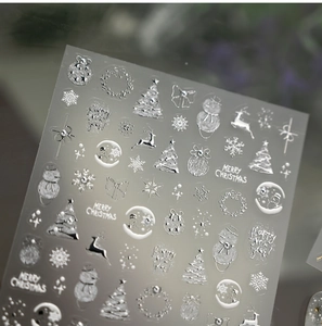 Nahaufnahme der silbernen geprägten Weihnachts-Nagelsticker mit Schneeflocken und Rentier-Motiven