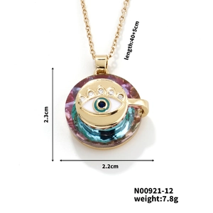Vue détaillée du pendentif œil doré avec cristaux colorés et dimensions 2,3x2,2 cm