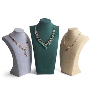Three velvet and linen necklace display busts in gray, green, and beige for jewelry sets