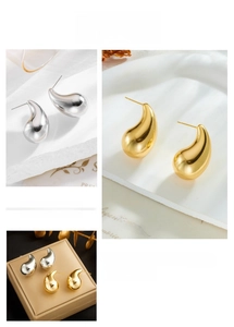 Detailed close-up of teardrop earrings in polished gold and silver finishes